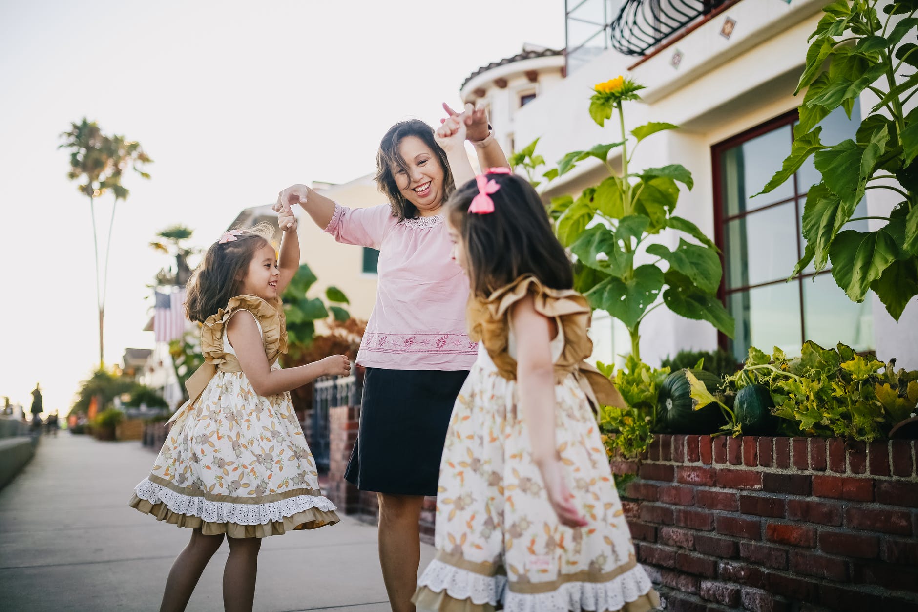 mother dancing with her daughters on the street